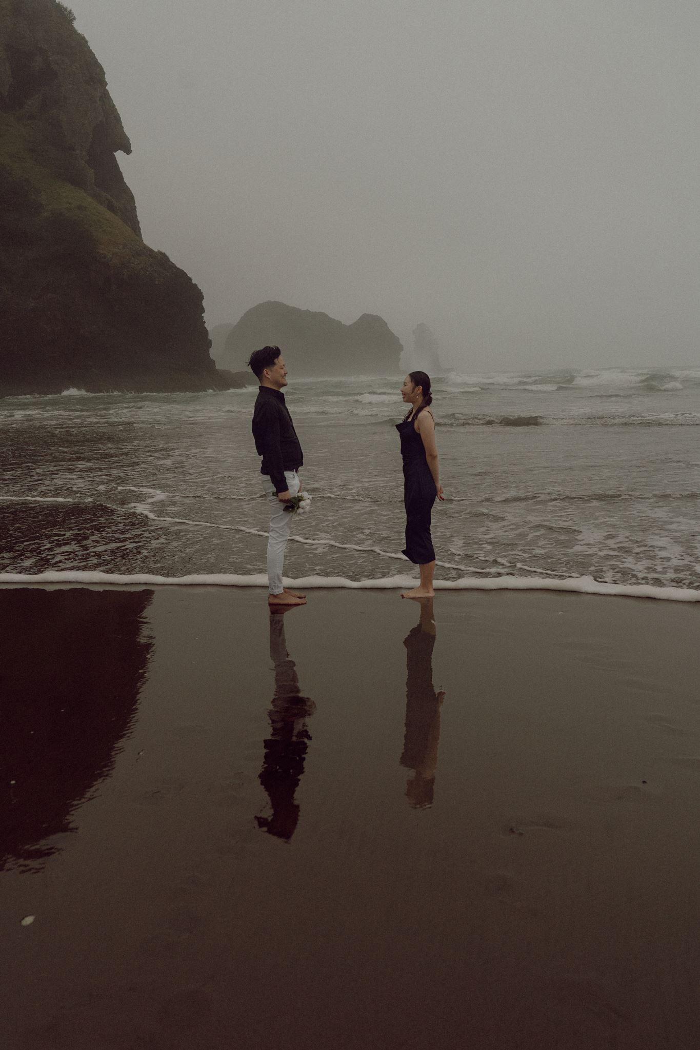 Elopement & mini wedding photographer Auckland — couple on Piha beach at sunset